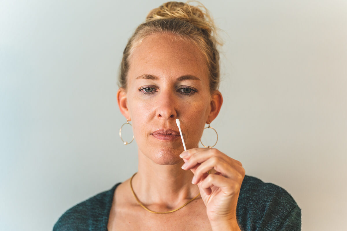 A woman uses a nasal swab